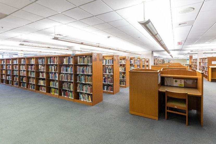 PGCC图书馆一层楼的内景. 一间光线充足的房间里堆满了书和桌子.